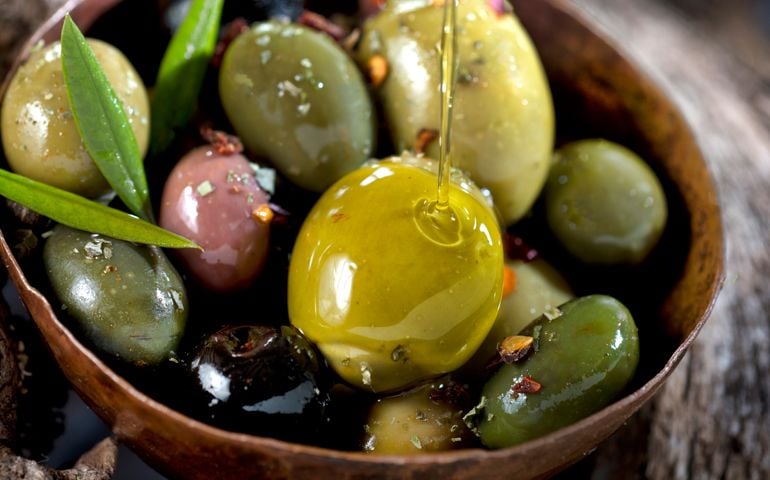 Olive fruit and leaves soaked in olive oil.