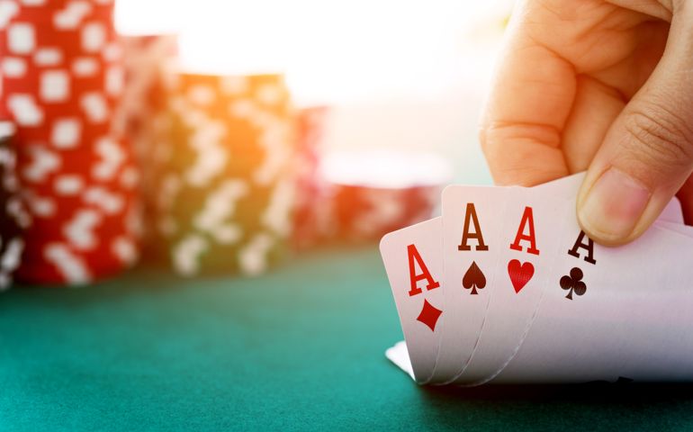 Woman hand revealing four aces