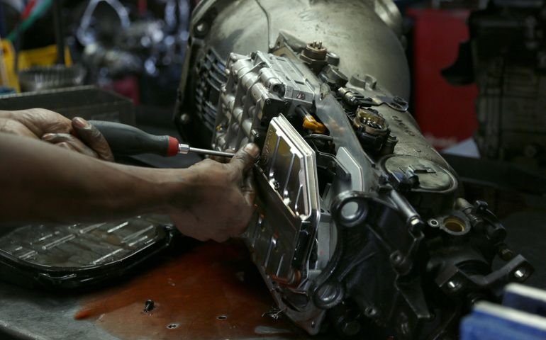 Auto shop owner taking apart his car transmission.