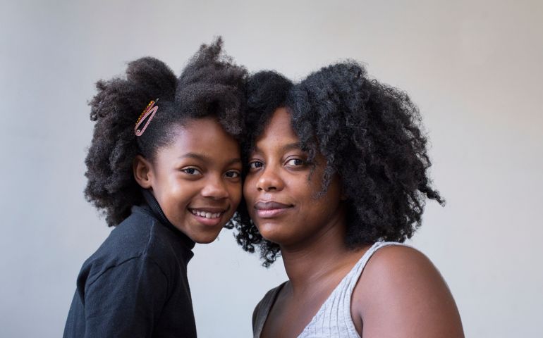 Portrait of a young mother and daughter with their kinky curly natural hair