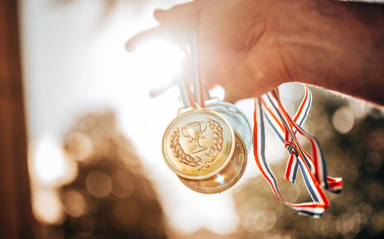 holding the medals for the winning
