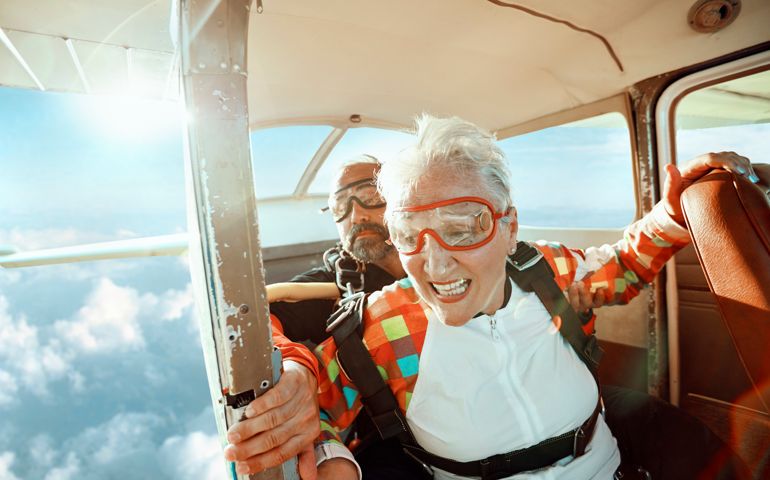 Close up of a senior woman and her instructor doing tandem skydiving