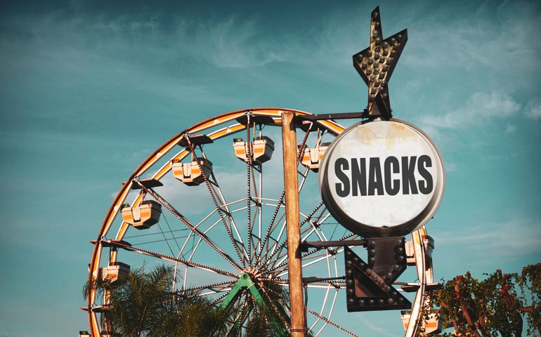 Aged and worn vintage photo of Ferris wheel and snack sign