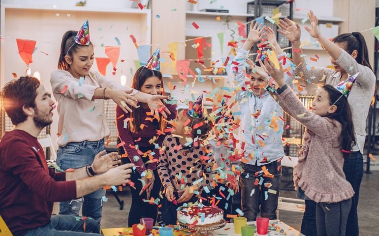 Group of people, teachers, parents and children in music school, having a children birthday party together.