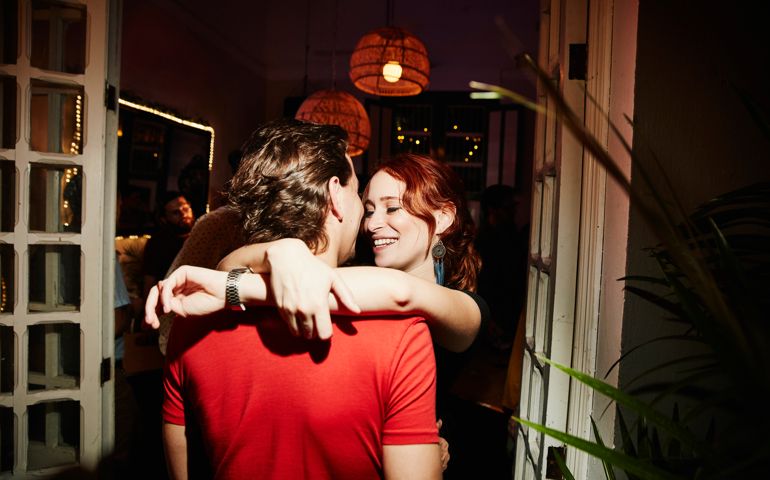 Smiling woman embracing boyfriend during party in night club