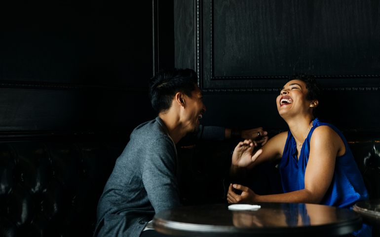 Cheerful woman talking to male partner at restaurant