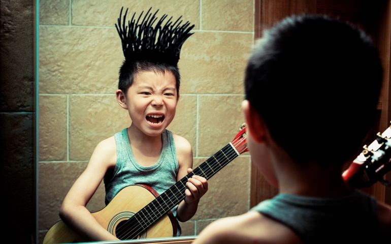 Little boy playing in the bathroom,His painting graffiti on the mirror,And apply it to their face, very interesting.