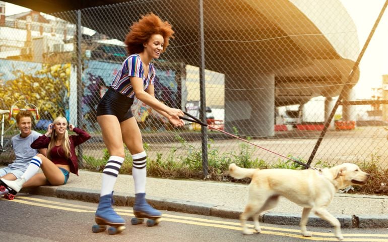 Young woman roller skating with dog