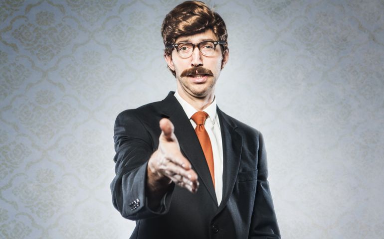 A stereotypical corporate manager type business man in full suit, big combover hairstyle and mustache looks at the camera with arm extended for a handshake. Intentional cliche look for humor. Horizontal image with copy space.