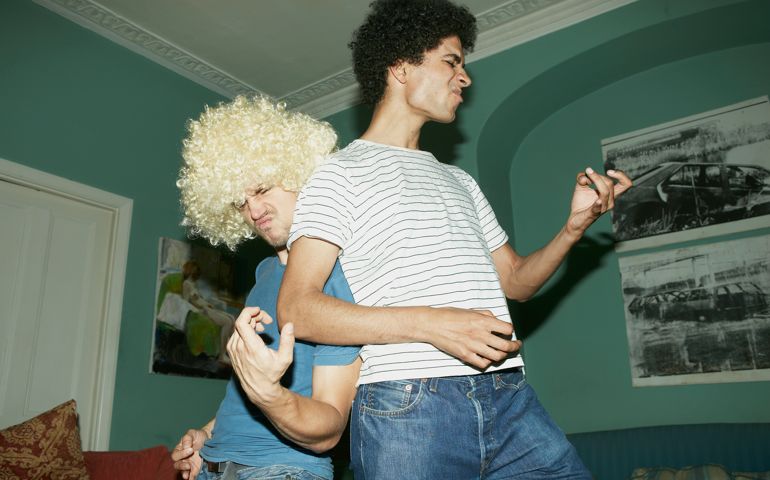 Two men playing air guitar