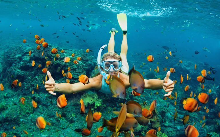 Happy family - girl in snorkeling mask dive underwater with tropical fishes in coral reef sea pool. Travel lifestyle, water sport outdoor adventure, swimming lessons on summer beach holiday with kids