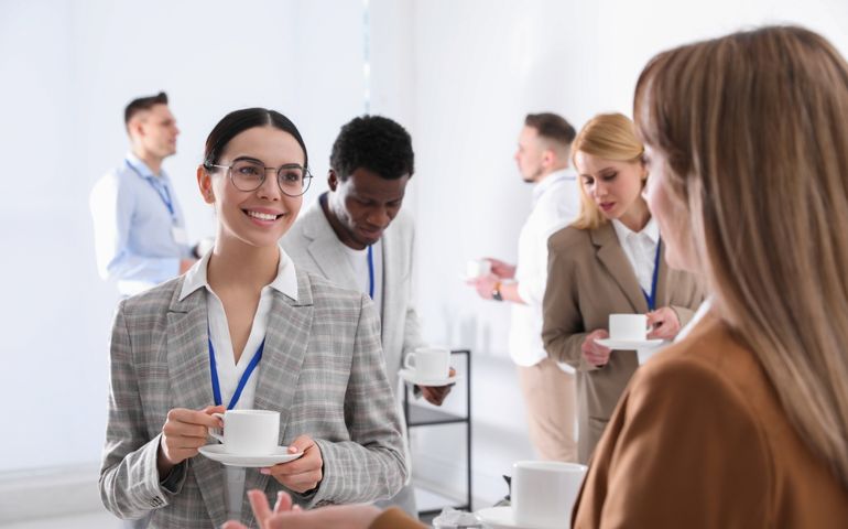 Group of people chatting during coffee break indoors