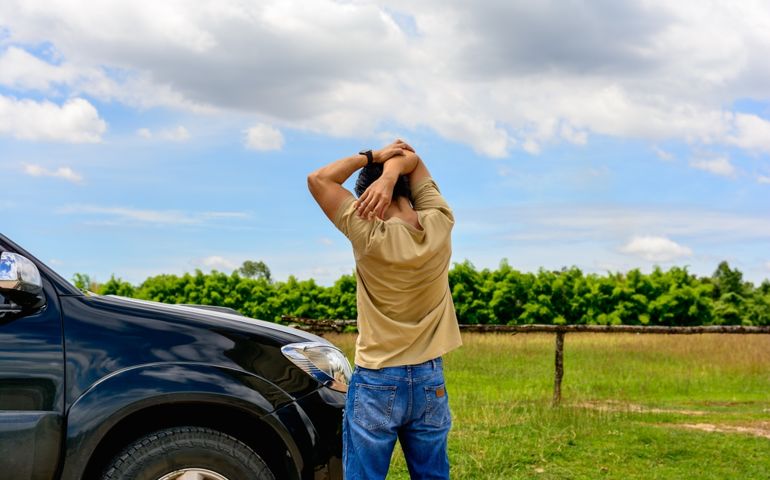 Man driver is stretching after a long drive. He exercises his body to relieve his body pain.