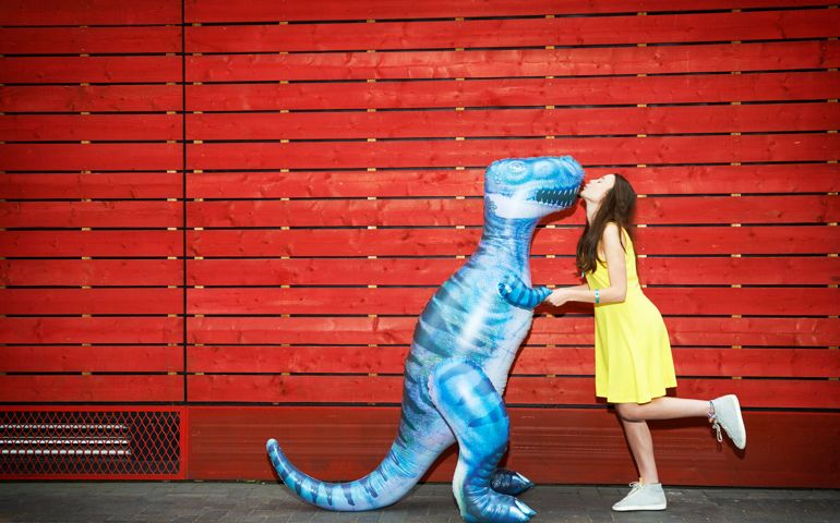 woman kissing toy dinosaur