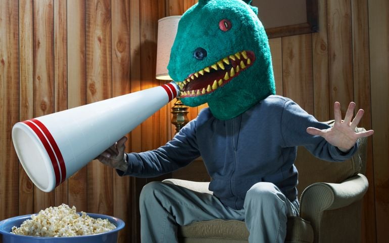 Dinosaur watching TV. and cheering with megaphone
