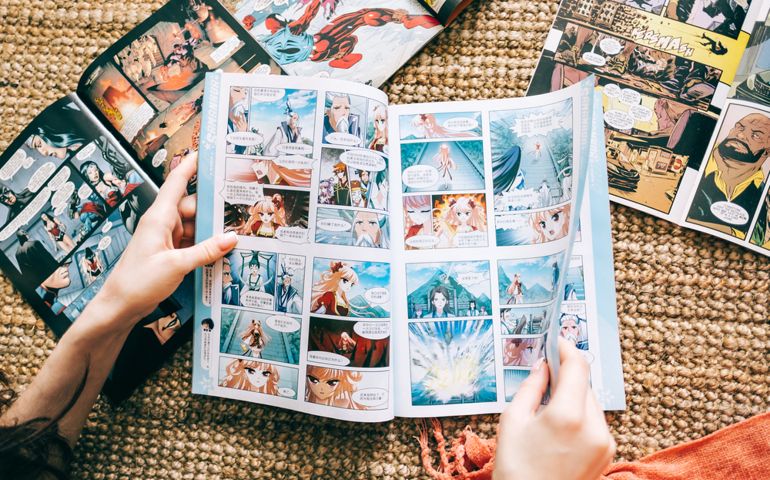 Woman reads manga comic book on the carpet at home