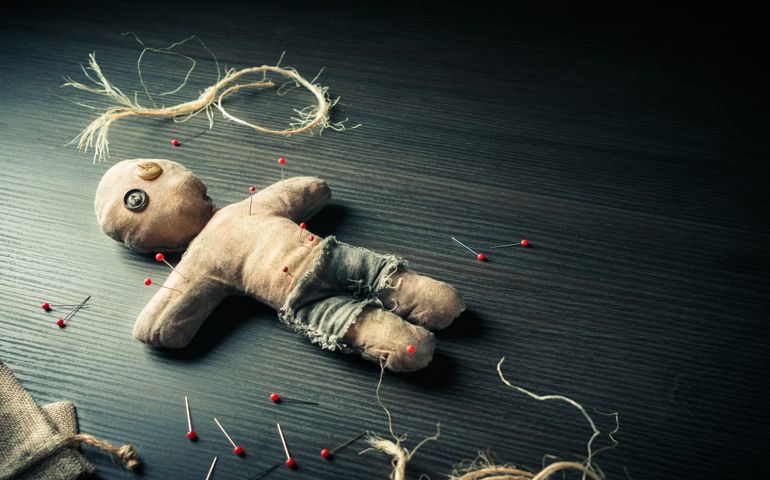 Voodoo Doll on a wooden background with dramatic lighting
