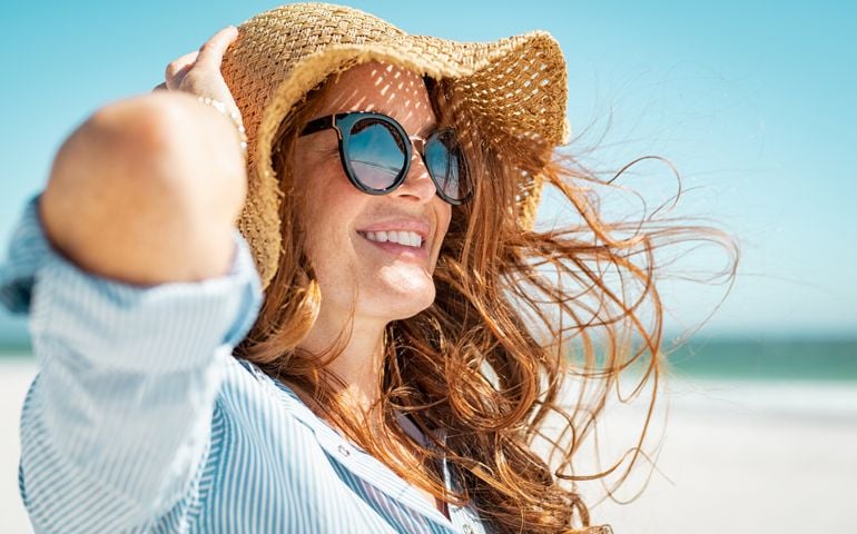 Mature woman with beach hat and sunglasses