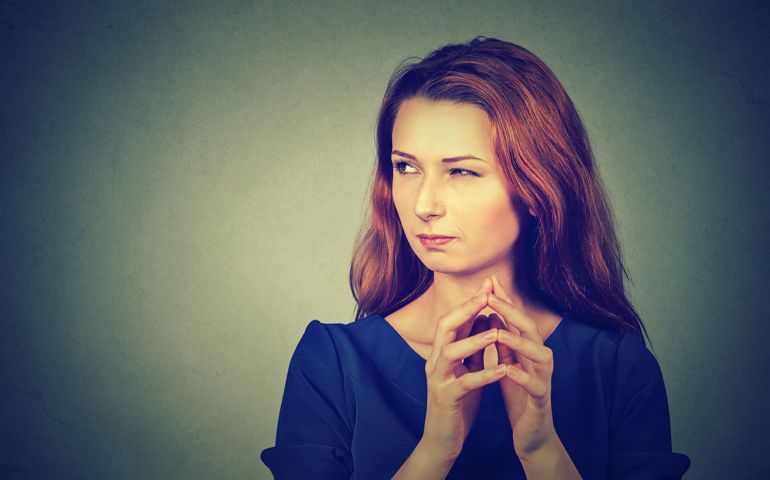 Closeup portrait of sneaky, sly, scheming young woman plotting something isolated on gray background. Negative human emotions, facial expressions, feelings, attitude