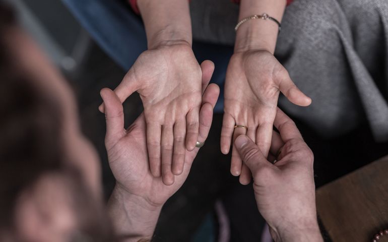 Palm lines. Top view of female palms being in chiromancers hands during the fortune telling session