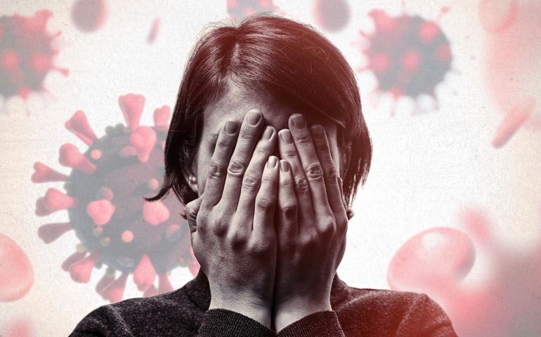 Concept of fear of coronavirus. Woman covers her face her hands on background with coronavirus.