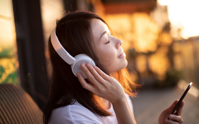 young woman smiling and listening to music
