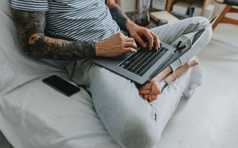 The new normal: unrecognizable young businessman working remotely from his home on a laptop PC