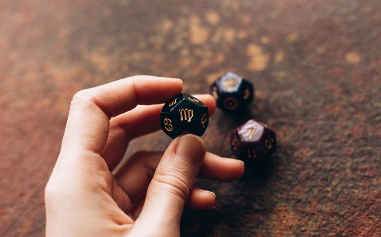 Beautiful astrological cube with the sign of Virgo in a female hand on a white background with place for text