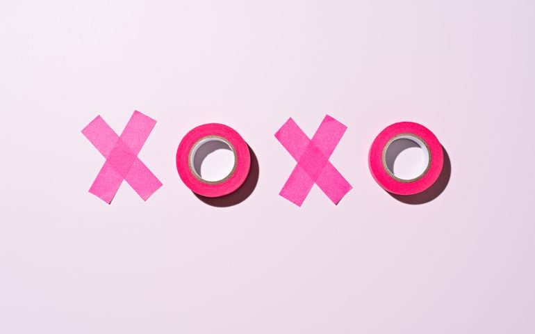XOXO Word Made of Pink Adhesive Tape on Pink Background Directly Above View.