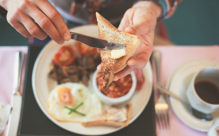 Closeup on a young woman's hands as she is having breakfast