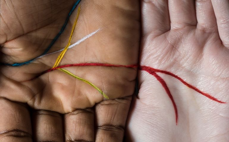 Hands side by side, colour lines run through