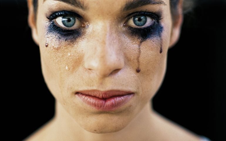 Young woman wearing black eye make-up, crying, close-up