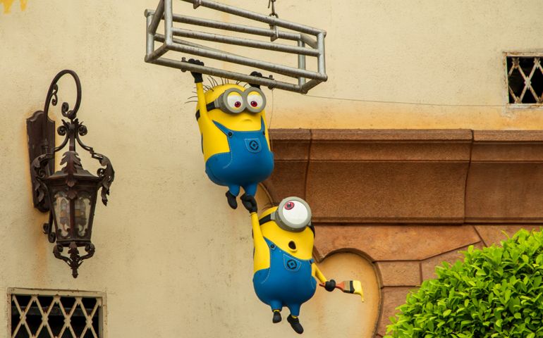 Minions a famous yellow cartoon character hanging from metal cage with paint brush in hand decorate at Minion Mart shop in Universal Studios