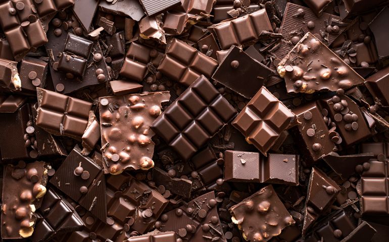 Assorted chocolate bar and chunks, background. Flat lay with a multitude of chocolate kinds. Delicious cocoa dessert. Baking chocolate collection.
