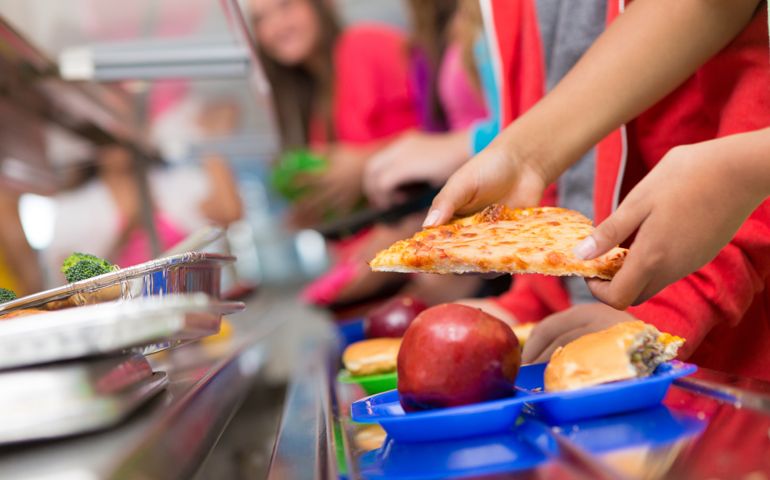 School children getting food in the cafeteria line.