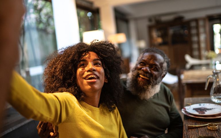 Young woman taking a selfie or doing a video call with her grandfather at home