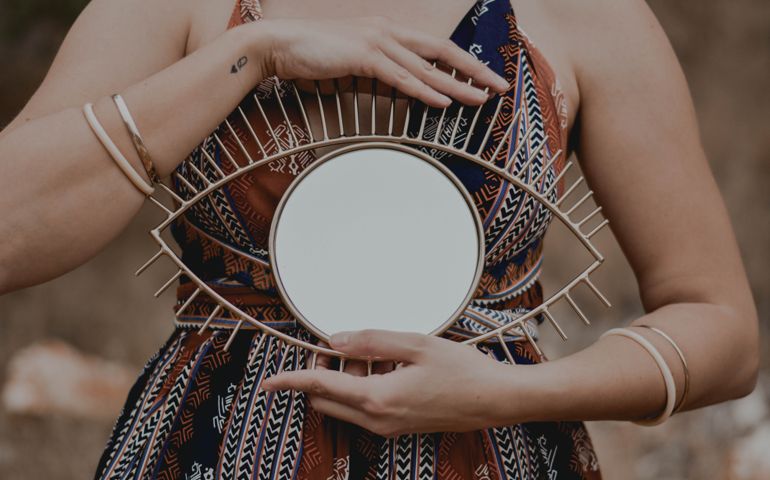 Girl holding an eye-shaped mirror