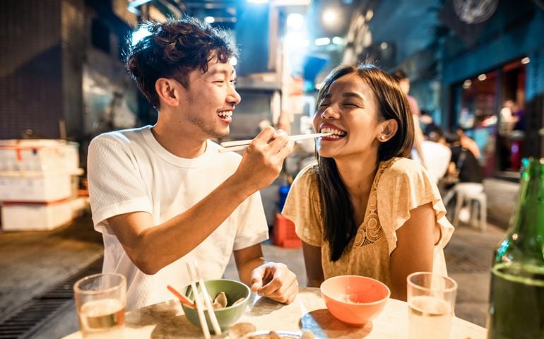 Asian couple enjoying street food in Hong Kong