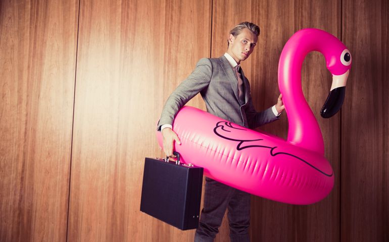 Businessman and a pink flamingo in front of a stylish wooden wall