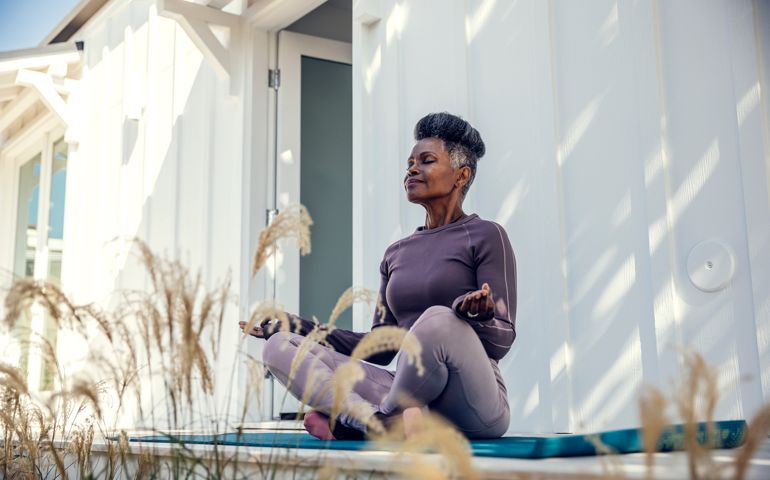 Mature woman meditating in backyard