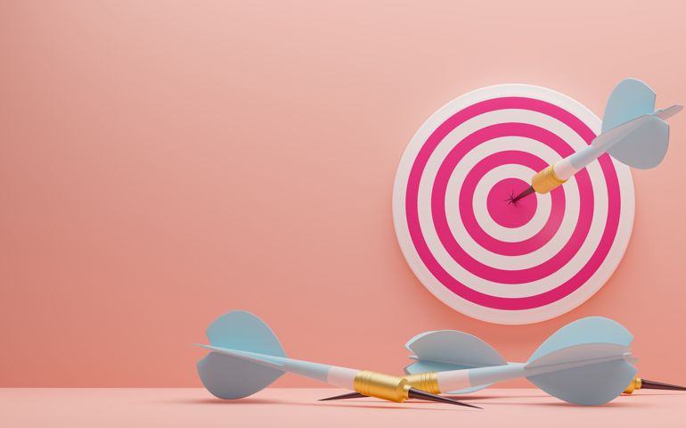 Blue Arrow hitting the center of target on the wall. Arrows that missed the target lie on the floor