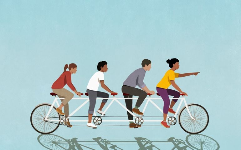 Friends riding tandem bicycle on blue background