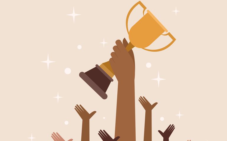 Hand holding a trophy cheered by others