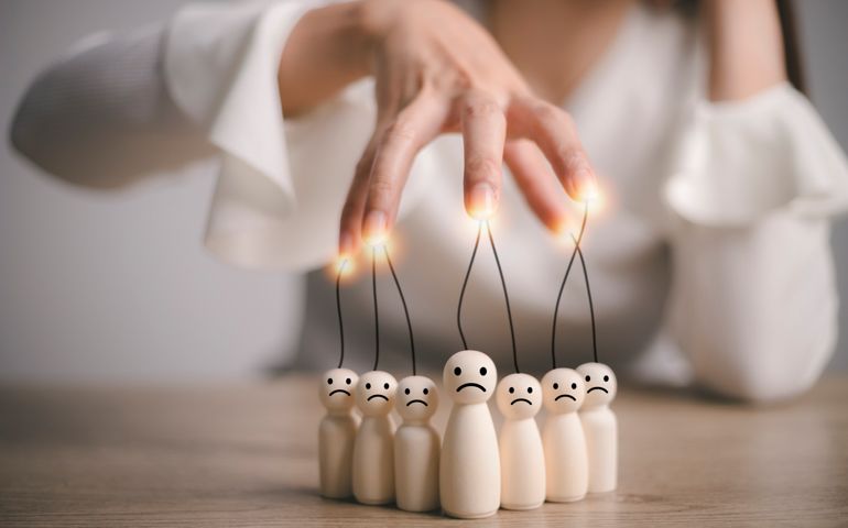 businesswoman controlling Wooden figures and manipulating concept