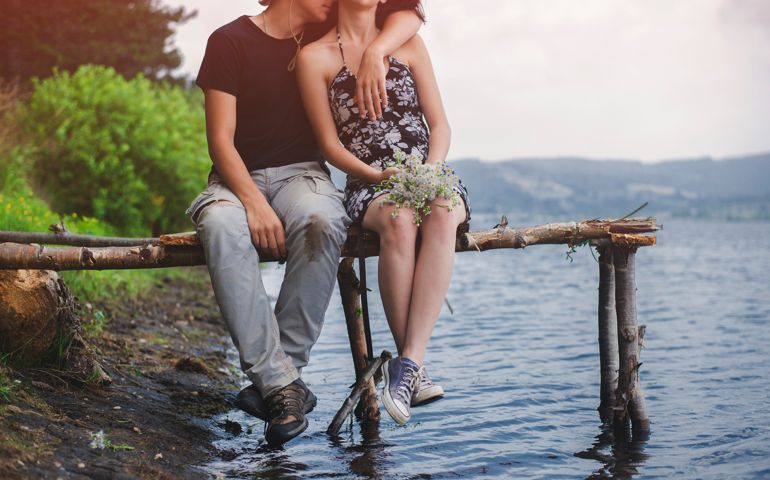 A couple enyoing and relaxing by the lake.