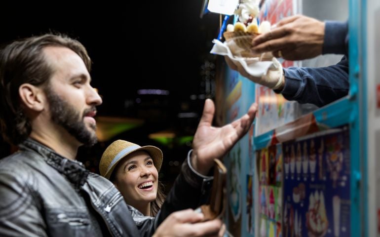 Couple Customers Receiving Ice Cream Product at the Food Truck at night