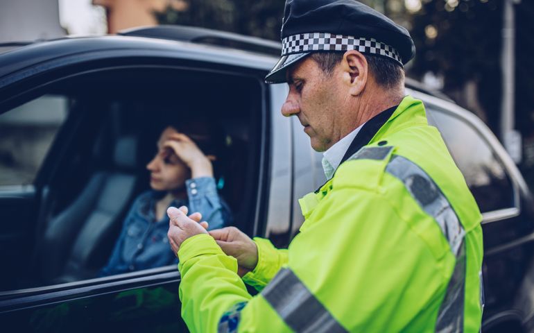 Young woman pulled over by police officer on the road.