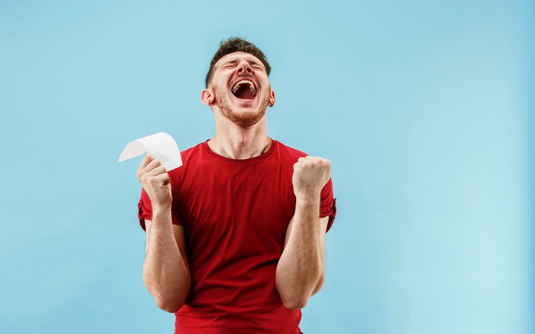 Young boy with a surprised expression bet slip on blue background