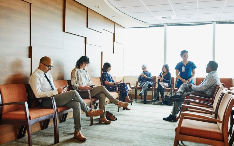 Nurse greeting patient in medical office waiting room