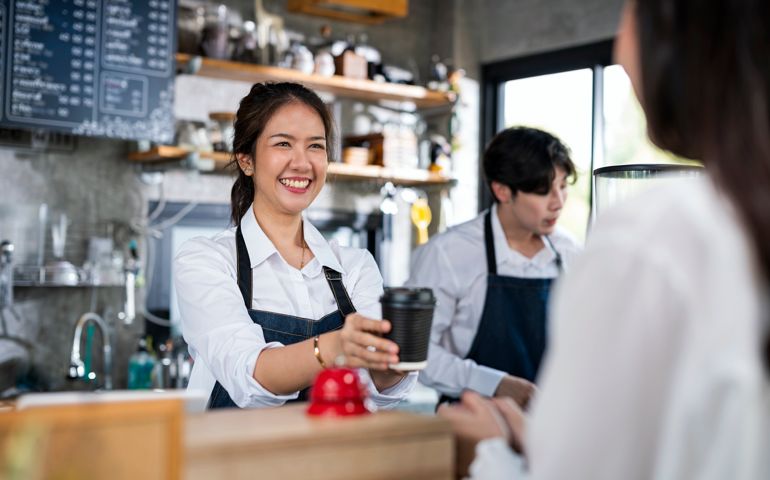 Shot of a Female barista serving a cup of coffee to a customer in a cafe counter. Small Business owner, Service mind and Customer service.